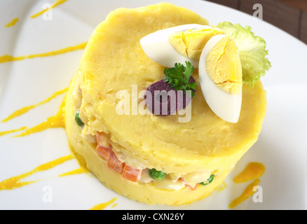 Traditionelle peruanische Gericht namens Causa gemacht von gelben und weißen Kartoffelpüree gemischt mit Aji (Paprika), gefüllt mit Gemüse Stockfoto