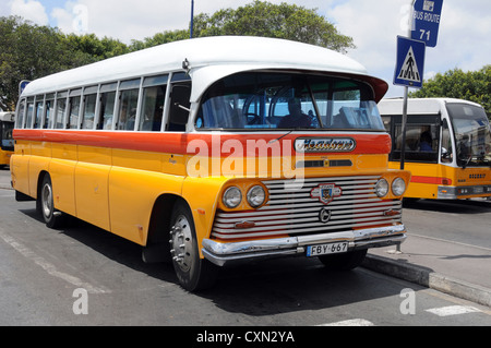 Leuchtend gelbe Jahrgang britischen Bus Haltestelle in Valetta Malta. 1960er Jahre voller Länge in hellem Sonnenlicht. Stockfoto