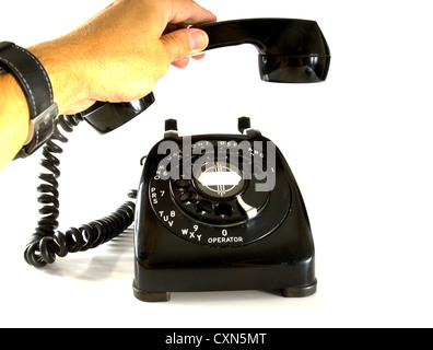 Menschenhand abnehmen des Hörers an einem 50er Jahre Vintage Telefon Stockfoto