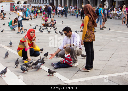 Familie füttern Tauben in St Marks Platz Venedig Italien Stockfoto