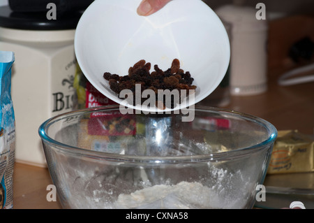 Kochen Sie hinzufügen von Trockenfrüchten zu einer Backmischung In eine Schüssel Zuhause backen Stockfoto