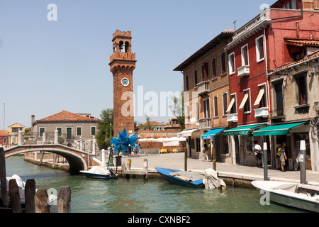 Die Bell Tower San Giacomo auf der Insel Murano in der Nähe von Venedig mit Ladenfronten und gebogenen Brücke Stockfoto