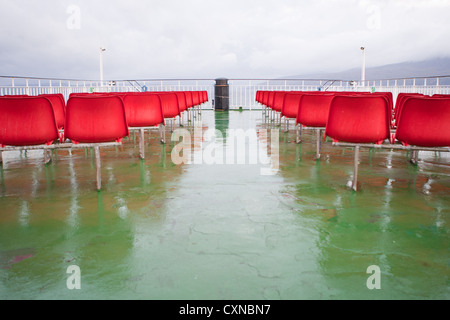 Leere rote Sitze auf Caledonian MacBrayne Fähre, Schottland. Stockfoto