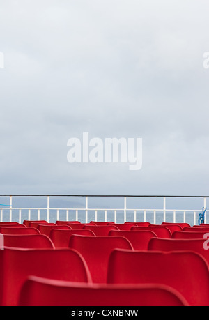 Leere rote Sitze auf Caledonian MacBrayne Fähre, Schottland. Stockfoto