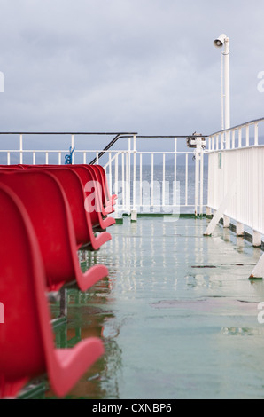 Leere rote Sitze auf Caledonian MacBrayne Fähre, Schottland. Stockfoto