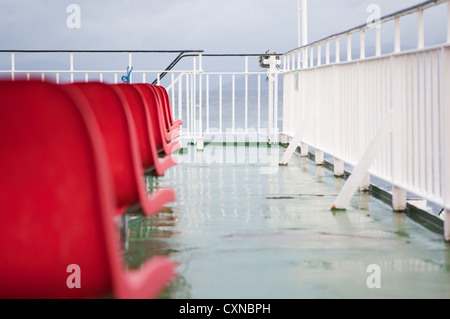 Leere rote Sitze auf Caledonian MacBrayne Fähre, Schottland. Stockfoto