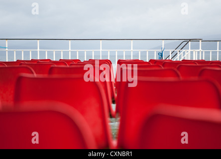 Leere rote Sitze auf Caledonian MacBrayne Fähre, Schottland. Stockfoto