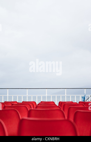 Leere rote Sitze auf Caledonian MacBrayne Fähre, Schottland. Stockfoto