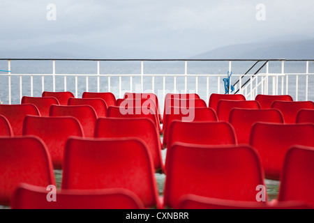 Leere rote Sitze auf Caledonian MacBrayne Fähre, Schottland. Stockfoto