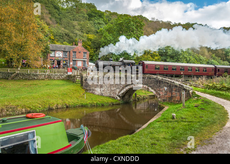 Black Lion Pub Consall auf das Churnet Valley Railway mit einem Steam train vorbei über den Caldon Kanal in Staffordshire. Stockfoto