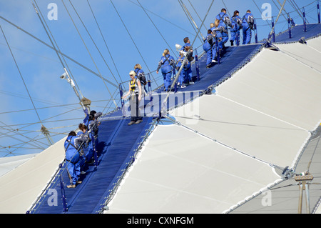 Bis auf die O2 ausgestattet mit Menschen in blauen Overalls gehen auf Dach der o2-Arena, manchmal auch als der Skywalk Stockfoto