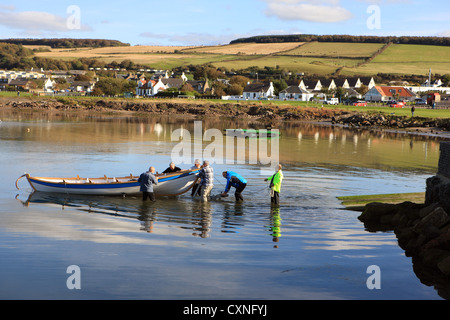 Männer, die Einführung eines Bootes im Hafen von Dunure in Ayrshire, Schottland Stockfoto