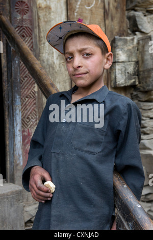 Kalash junge auf den Stufen eines Hauses am Krakl Dorf, Bumburet Tal, Chitral, Khyber-Pakhtunkhwa, Pakistan Stockfoto