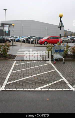 Kreuz hier Straßenquerung in einen Supermarkt Parkplatz mit Zebra-Markierungen und ein shopping trolley Stockfoto