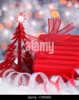 Weihnachten rote Geschenkbox als Hintergrund Weihnachtskarte mit Weihnachtsbaum Ornament & abstrakte Unschärfe Lichter Dekoration Stockfoto
