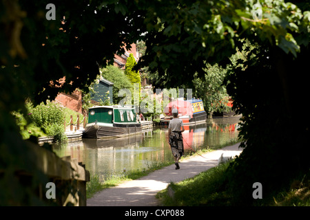 Eine Frau geht ihren Hund auf dem Fazeley Kanal in Tamworth, Staffordshire. Hier abgebildet die Strecke des Kanals hinter dem Yachthafen. Stockfoto