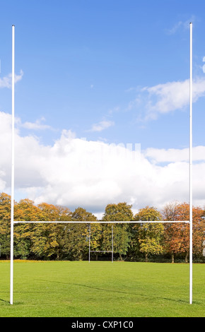 Rugby-Beiträge auf der grünen Wiese mit Bäumen und blauen Himmel Stockfoto