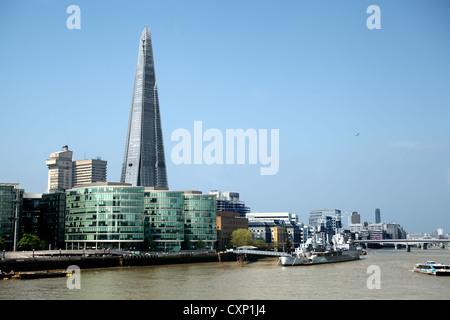 Ein Bild über den Fluss Themse in London, zeigt WW2-Schlachtschiff HMS Belfast im Vordergrund, jetzt ein schwimmendes Museum und die Scherbe im Hintergrund Stockfoto