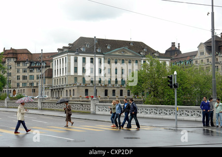 Menschen beim Überqueren der Straße in der Nähe der Brücke über den Fluss Limmat in Zürich. Hatte kürzlich geregnet und war ein Feiertag, so dass weniger Menschen auf. Stockfoto
