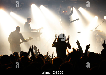 Silhouetted Zuschauer/Masse und Ambiente während live Rock Konzert mit Rocker auf der Bühne durch Strahler beleuchtet Stockfoto