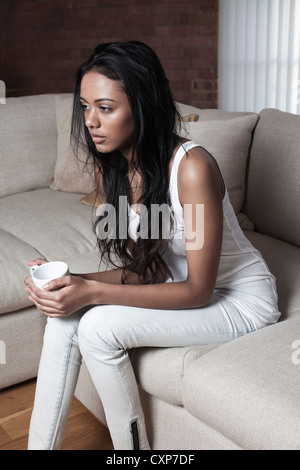 Frau denken alleine zuhause auf dem Sofa Stockfoto