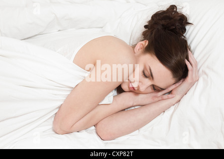 Schlafen. Junge Frau allein im Bett Stockfoto