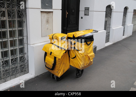 Ein stark belasteter österreichische Briefträger Warenkorb/Trolley geparkt vor einem Hotel in Wien, Österreich. Stockfoto