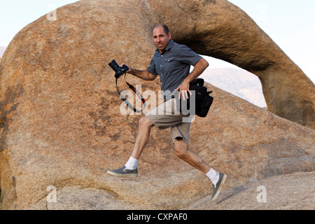 Fotograf, springen, vorbei an der Alabama Hills Arch, Lone Pine, Kalifornien, Vereinigte Staaten von Amerika Stockfoto