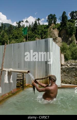 Ein Hindu Sadhu (Heiliger) nimmt ein Bad in einer heißen Quelle in der Nähe von Manali, Nord-Indien Stockfoto