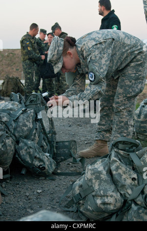 Ein Südcarolina National Guard Soldat sichert Ihr Ruck sack wie die Sonne vor Beginn der dänischen Kontingent März Oktober 6. Die dancon beginnt und endet im Camp Novo Selo, die Beteiligten auf der 25,85 Kilometer langen Marsch durch einige der Bereiche mehr herausforderndes Gelände. Stockfoto