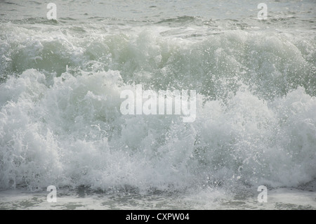 Eine große Welle brechen auf Chesil Beach, an der Küste von Dorset, bei stürmischem Wetter. England, United Kingdom. Stockfoto