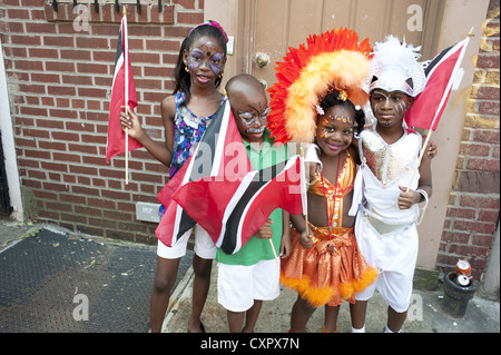 USA: Brooklyn, NY. Kostümierte Kinder mit den Fahnen von Trinidad und Tobago erwarten den Beginn der Karibik Kiddies Parade. Stockfoto