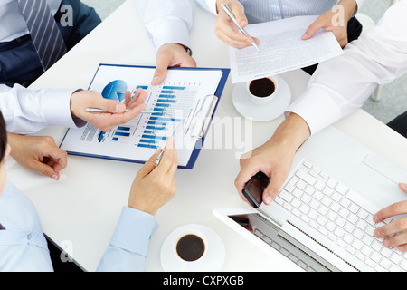 Bild von Menschenhand mit Stiften über geschäftliche Dokumente der Tagung Stockfoto