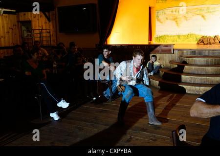 Cowboy Schütze mit Pistole Aktion alten amerikanischen Westens schießen auf historischen authentische Nachbildung Schießerei Reenactment den Salon-Club. Stockfoto