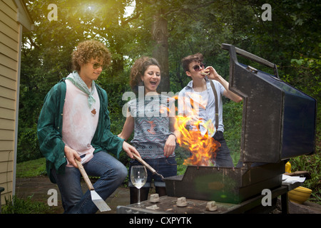 Junge Erwachsene Freunde genießen einen Hinterhof Grill Stockfoto