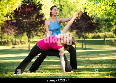 Yoga-Lehrer und Schüler im park Stockfoto