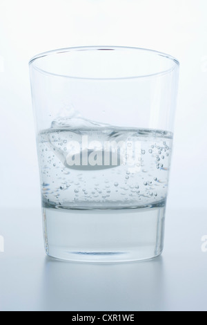 Pille in Glas Wasser Stockfoto