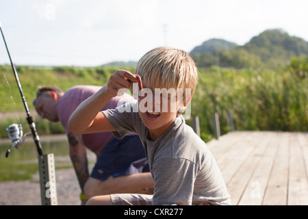 Vater und Sohn Angeln, junge Holding Wurm Stockfoto