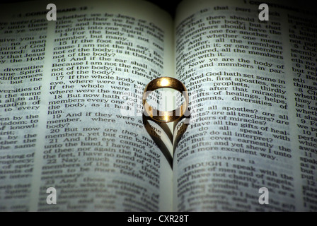 Ring und Herz geformt Schatten über eine Bibel