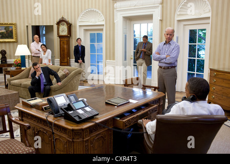 US-Präsident Barack Obama spricht am Telefon mit House Minority Leader Nancy Pelosi 31. Juli 2011 im Oval Office, laufende Bemühungen in den Gesprächen zum Schulden begrenzen und Defizit Abbau zu diskutieren. Abgebildet, von links, sind: Phil Schiliro; Assistent des Präsidenten und Sonderberater; Senior Berater David Plouffe; Nancy-Ann DeParle, Deputy Chief Of Staff für die Politik; Bruce Reed, Chef des Stabes des Vice President; Rob Nabors, Assistent des Präsidenten für Legislative Angelegenheiten; und Vize-Präsident Joe Biden. Stockfoto