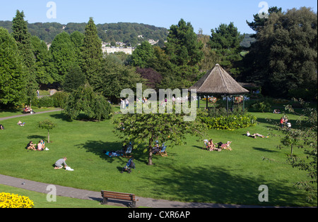 Menschen, die sich auf Grasrasen in Parade Gardens in Bath Somerset England, Großbritannien, entspannen Stockfoto