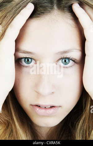 Young woman, portrait, holding her hands on her face Stockfoto