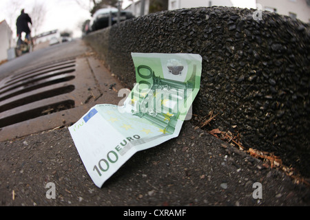 Euro-Banknote, Dachrinne, Abfluss, symbolisches Bild, Geld auf der Straße liegend Stockfoto