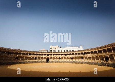 Sonnendurchflutetes hufeisenförmige Decks Sitzgelegenheiten umgeben die leere Stierkampfarena in der Arena von Ronda, Spanien. Stockfoto