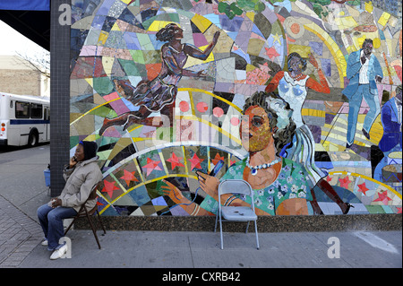 Man sitzt vor einem Mosaik auf der Fassade in Harlem, Manhattan, New York City, New York, USA, Nordamerika Stockfoto