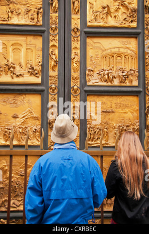 Zwei Touristen betrachten die Tore des Paradieses Etablissement Duomo in Florenz, Italien Stockfoto