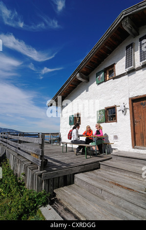 Weibliche Wanderer eine Pause bei einer privaten Berghütte auf Eggenalm Alp, Grenzgebiet zwischen Waidring, Tirol, Österreich Stockfoto