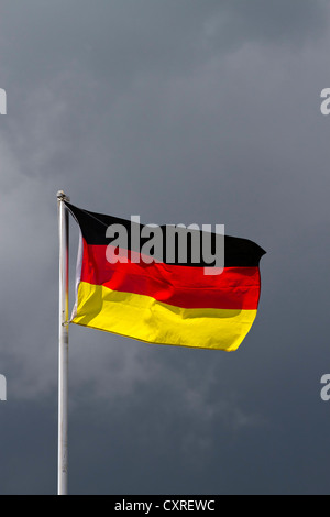Die deutsche Nationalflagge, dunkle Wolken am Rücken, symbolische Bild Stockfoto