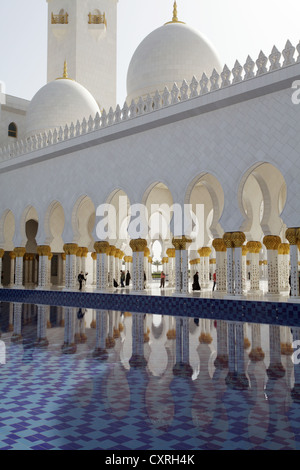 Kolonnade spiegelt sich in einer Lache des Wassers in der Sheikh-Zayed-Moschee in Abu Dhabi, Vereinigte Arabische Emirate, Naher Osten, Asien Stockfoto