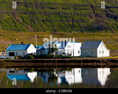 Reflexion auf See, blaue Dach-Häuser in Seydisfjordur, Osten, Island Stockfoto